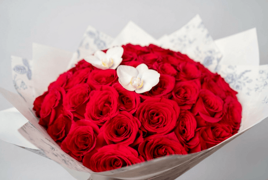Close-up of The Red Velvet bouquet with premium red roses and white orchids wrapped in white patterned paper