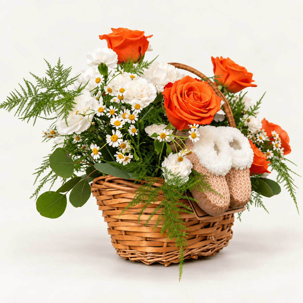 Baby flower basket with orange roses, white flowers, greenery and baby booties by AG Floral Studio in Miami