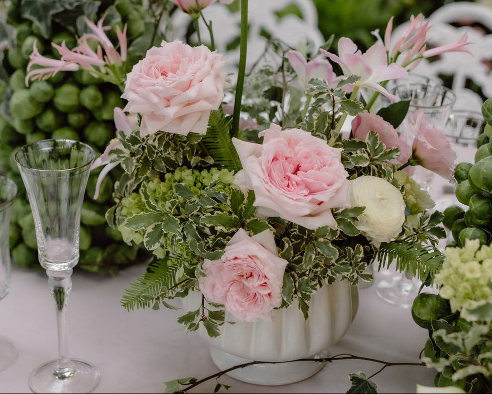Mediterranean-inspired wedding centerpiece with pink roses, greenery, and green grapes at a Miami reception