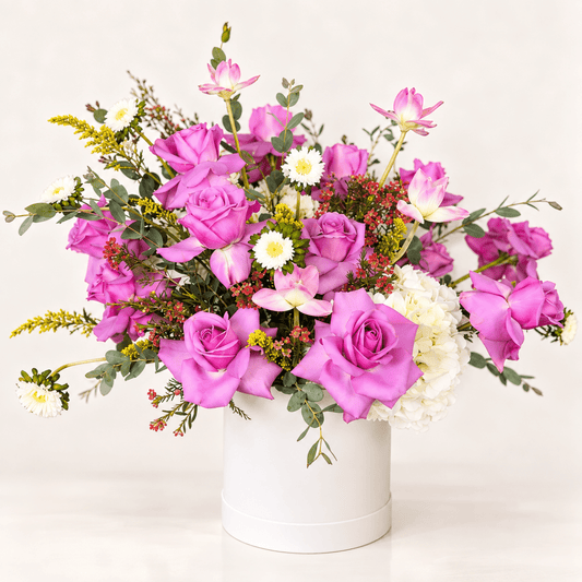 Lavender rose floral arrangement with white hydrangeas, pink seasonal flowers, accent blooms and greenery in a white hatbox