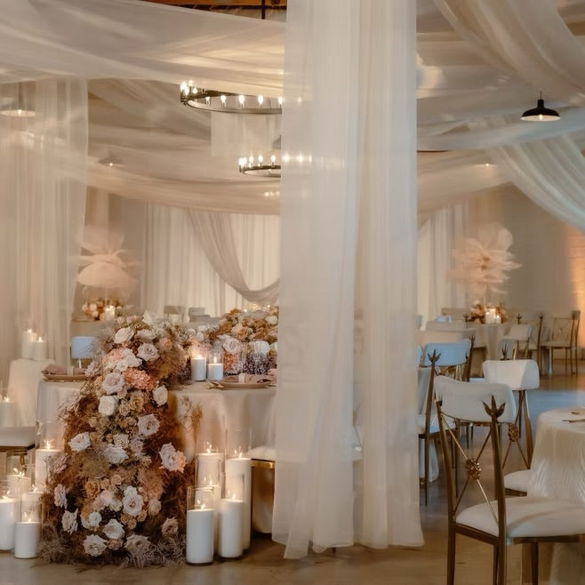 Decorative indoor setting with tables, chairs, and floral arrangements.