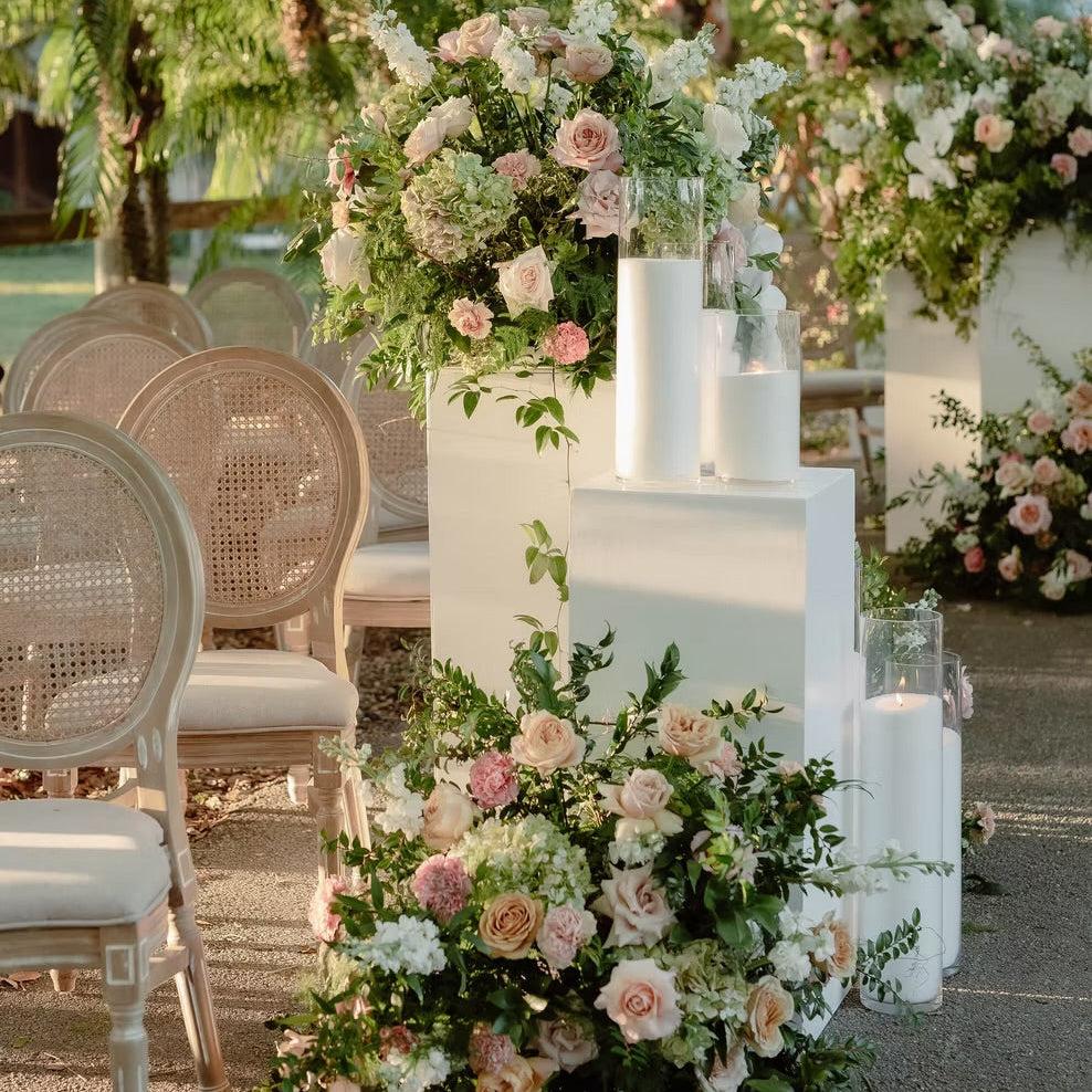 Decorative floral arrangements with white and pink flowers on a pathway outdoors.